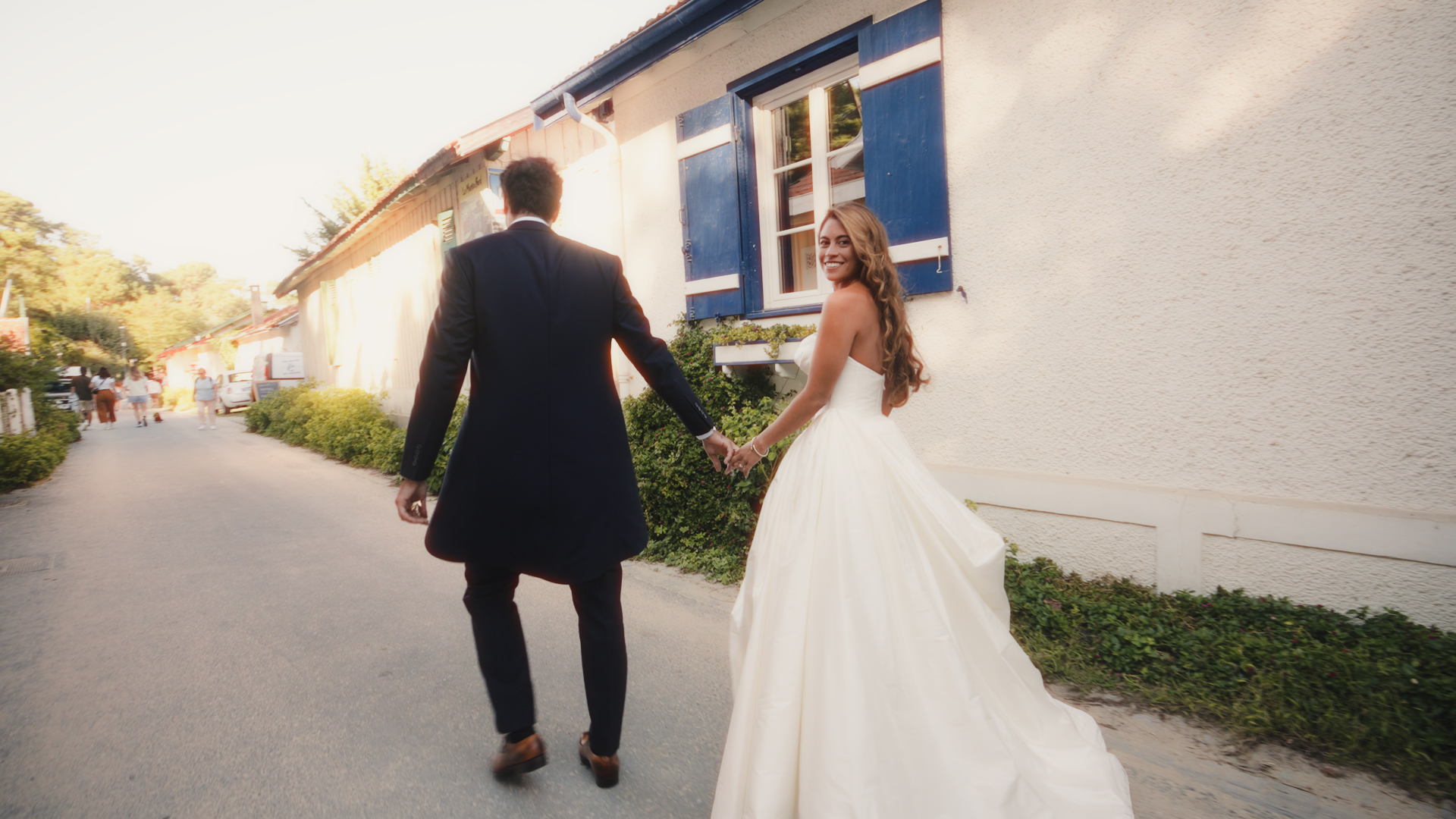 Barbara et Arthur marchant dans le village de l’Herbe au Cap Ferret après leur cérémonie de mariage