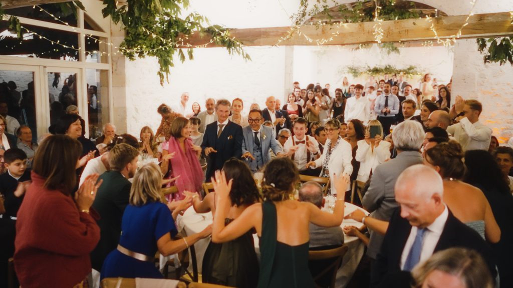 Invités célébrant et chantant lors du dîner de mariage au Château Vidasse