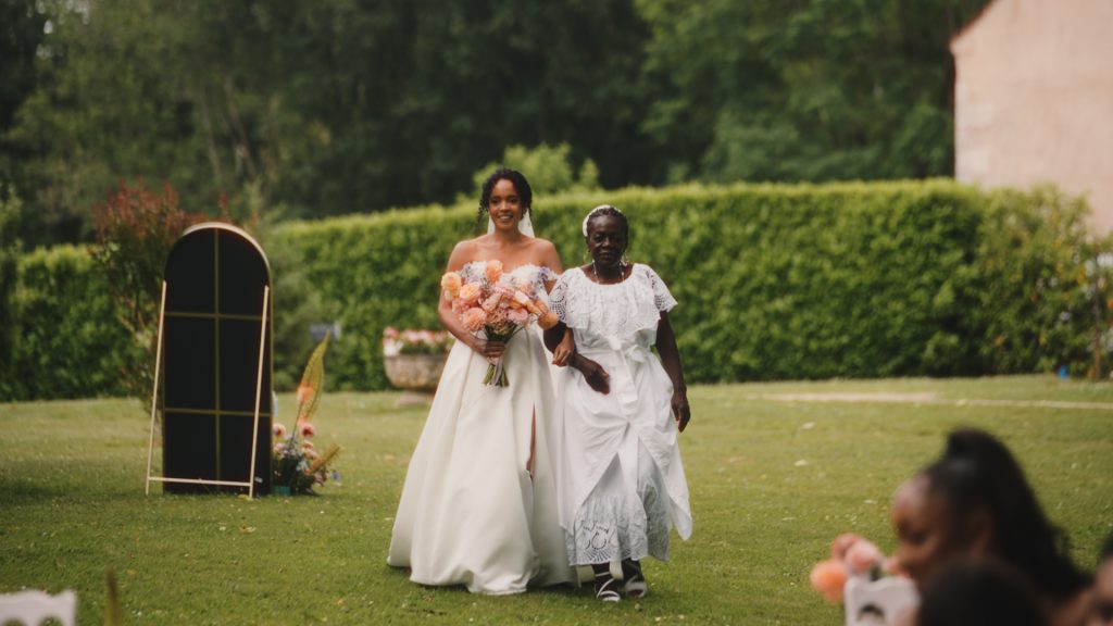 Bride walking down the aisle during an outdoor wedding ceremony in Dordogne