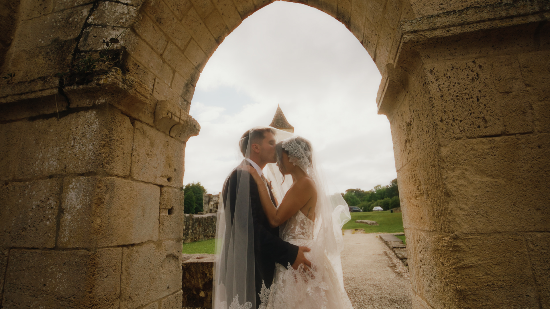 Julie et Alexis sous une arche de l’abbaye Saint-Maurice de Blasimon après leur cérémonie de mariage