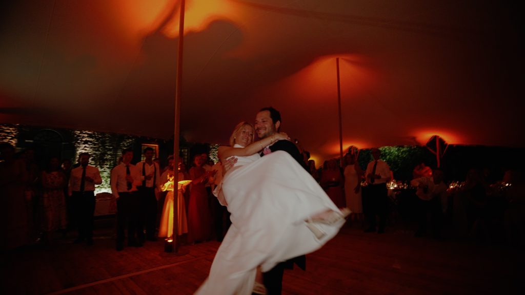 Louis portant Charlotte sur la piste de danse pendant leur soirée de mariage